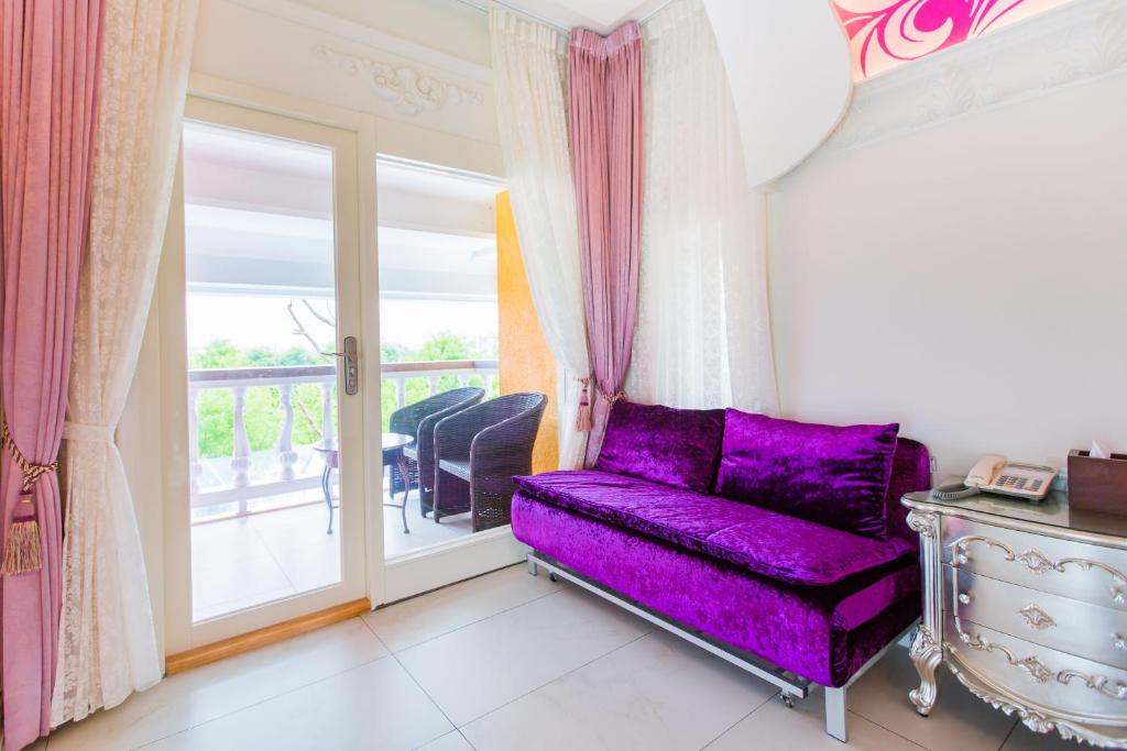 a purple couch in a room with a balcony at Jane Castle in Wujie