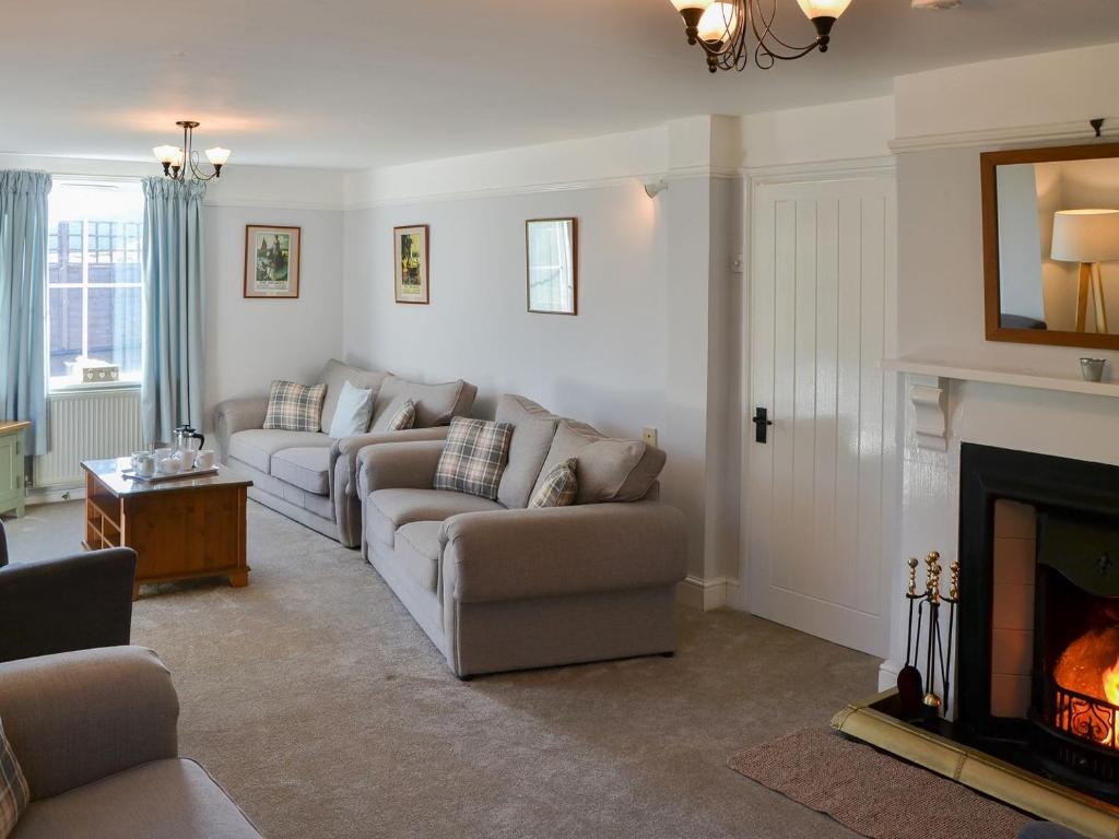 a living room with two couches and a fireplace at Riverside in Stalham