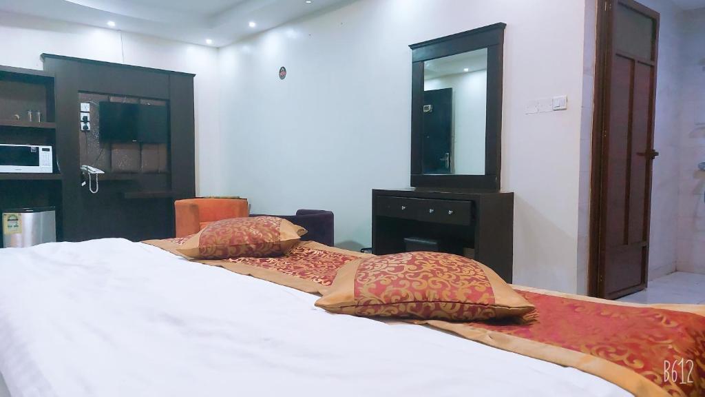 賈贊的住宿－غرف الصفا الشهري，一间卧室配有两张带枕头和镜子的床