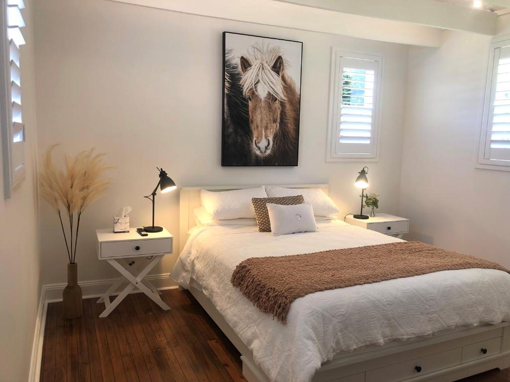een slaapkamer met een bed met een foto van een paard bij The Stables in Armidale