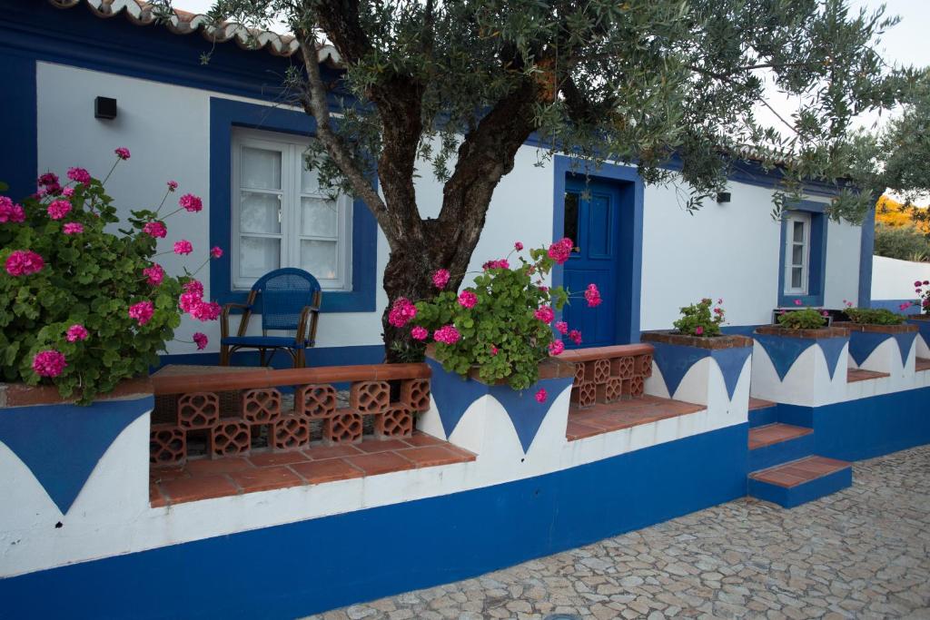 una casa azul y blanca con flores y un árbol en Tapada da Eira e Chanca, en Fortios