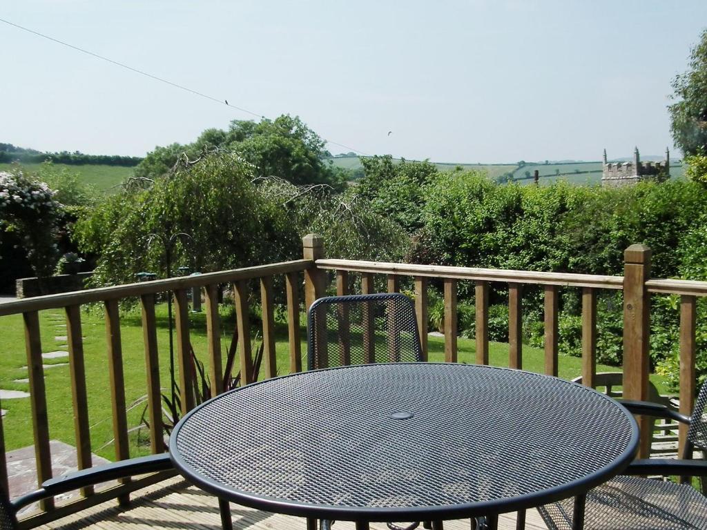 a table and chairs sitting on a balcony at Moonrakers in Ruan Lanihorne