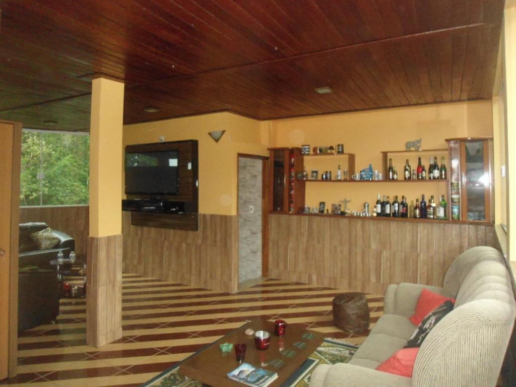 ein Wohnzimmer mit einem Sofa und einer Bar in der Unterkunft Hostel do Tucano in Rio de Janeiro