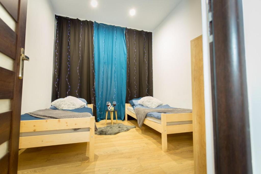 a room with two beds and a window at Centrum red apartament in Wałbrzych