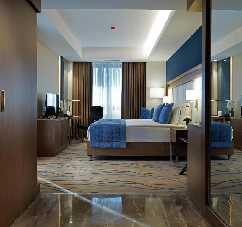 a hotel room with a bed and a desk at Dedeman Kayseri in Kayseri