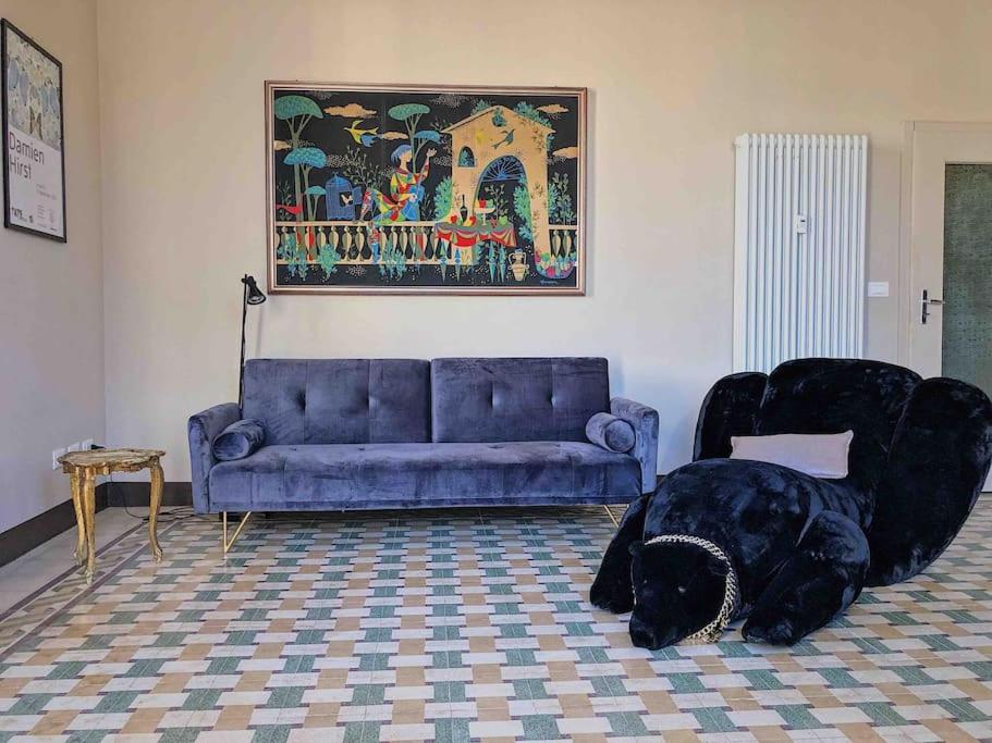 a living room with a couch and a dog laying in a chair at Appartamento design dèco in Bologna