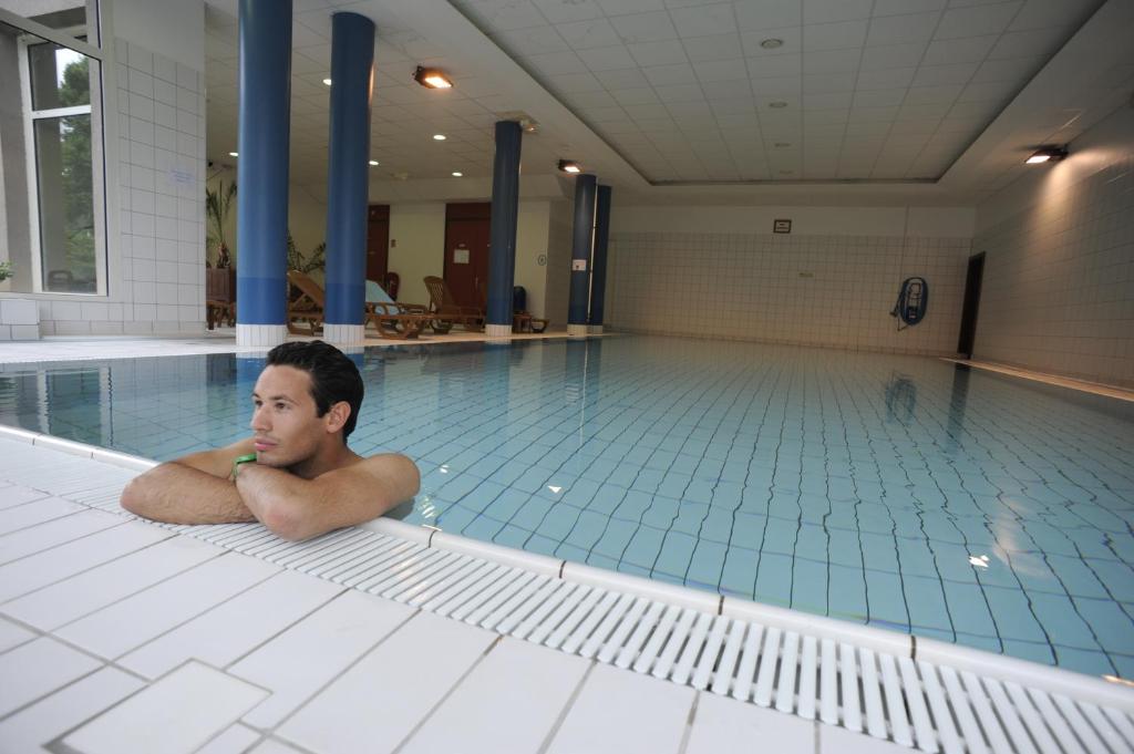 a man laying on the floor in a swimming pool at VVF Alsace Orbey Colmar in Orbey