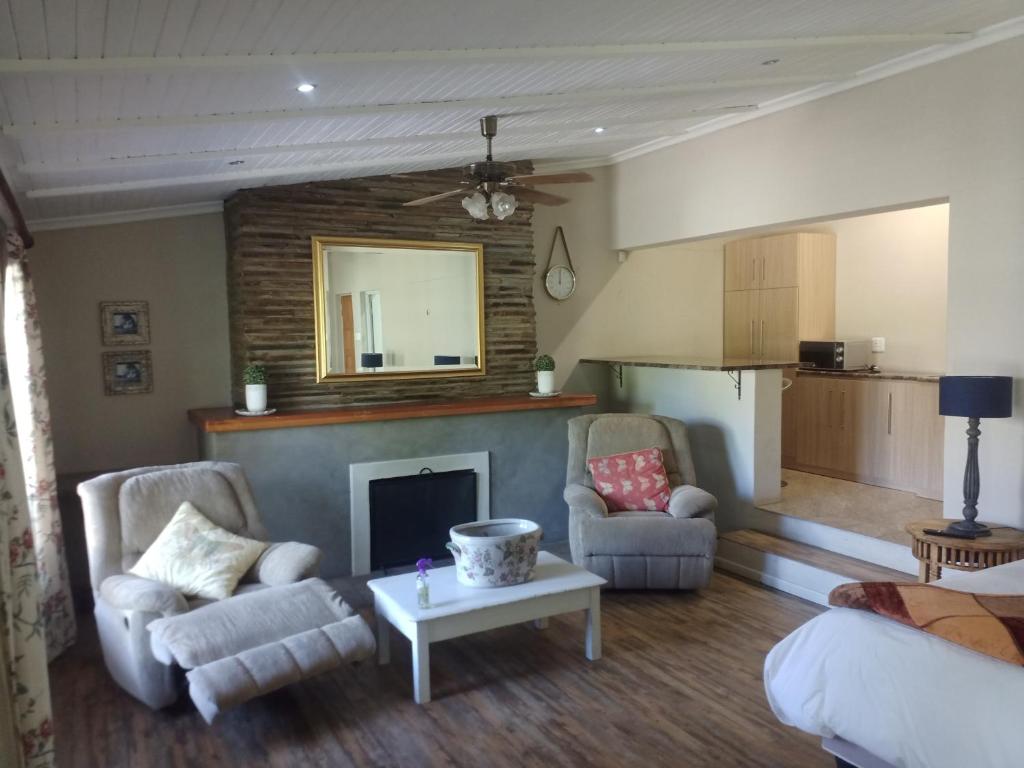 Una sala de estar con dos sillas y una chimenea. en Garden Court B&B, en Queenstown
