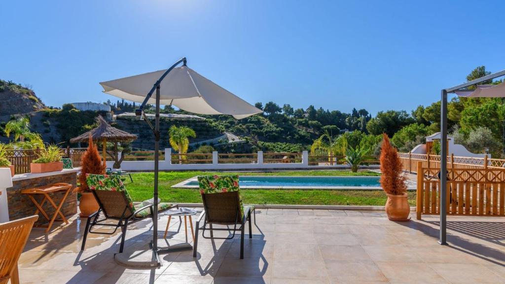 patio con tavolo, sedie e ombrellone di Villa Matella Vélez-Málaga by Ruralidays a Vélez-Málaga