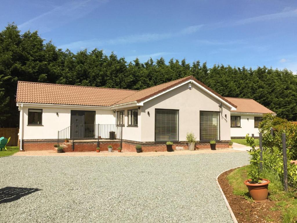 a white house with trees in the background at Lavender Lea in Henley in Arden