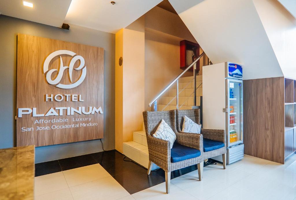 een lobby van een hotel met een bord en stoelen bij RedDoorz Plus @ Hotel Platinum Occidental Mindoro in San Jose