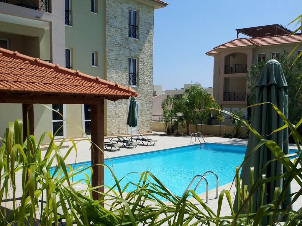 a swimming pool in front of a building at Mazotos Panoramic Village in Mazotos