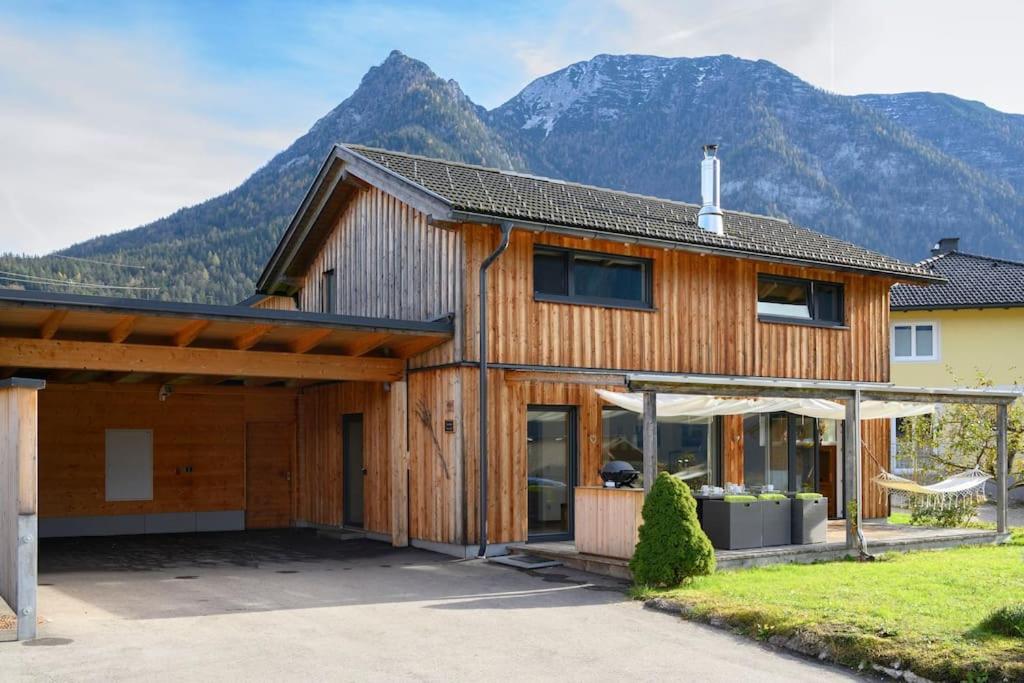 a wooden house with mountains in the background at Ferienlodge MariAndl in Bad Goisern