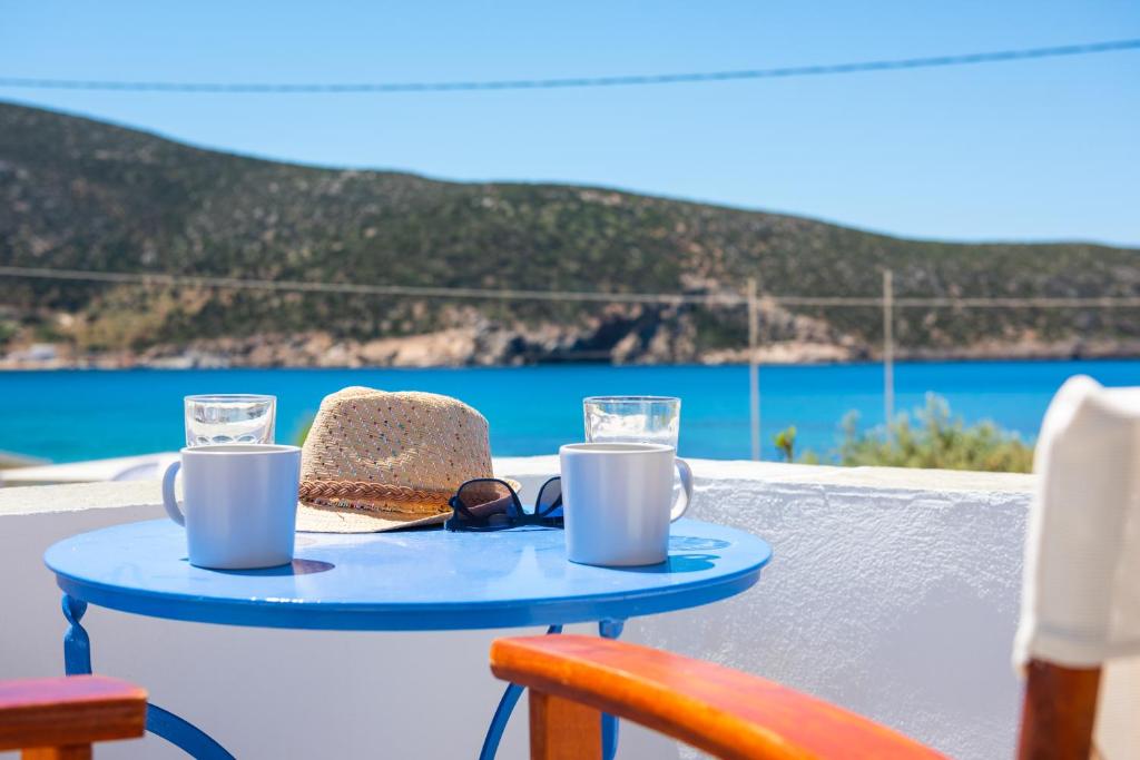 a blue table with a cake and glasses on it at KALYPSO ACCOMMODATION SIFNOS in Vathi