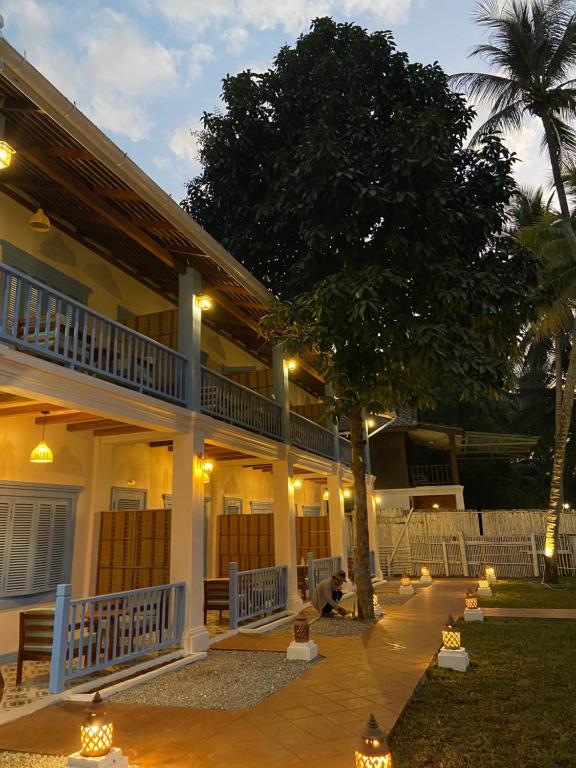 uma casa com uma árvore em frente em Sadakham Hotel em Luang Prabang