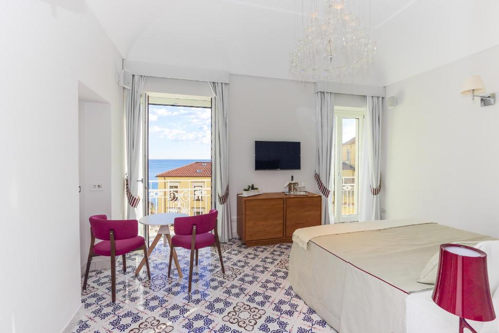 een slaapkamer met een bed en een tafel en stoelen bij DieciSedici in Amalfi