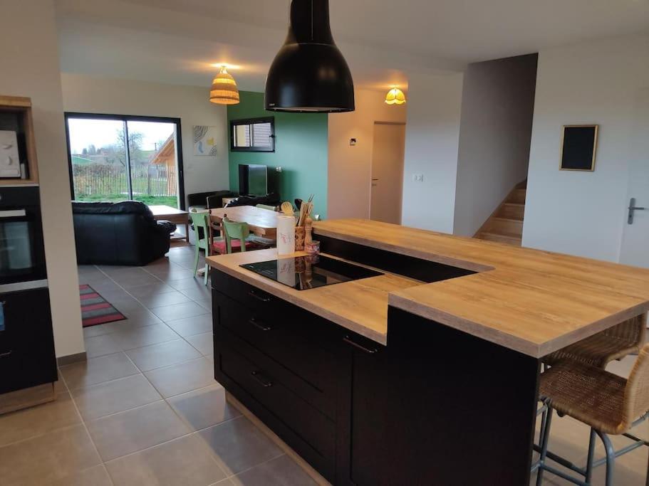 a kitchen with a counter top and a living room at Belle maison au calme à 20 min d'Annecy - Vaulx in Vaulx