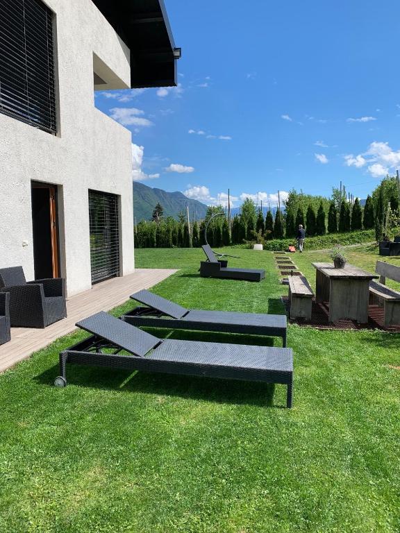a group of benches sitting on the grass next to a building at Weingut Bachgütl in Cermes
