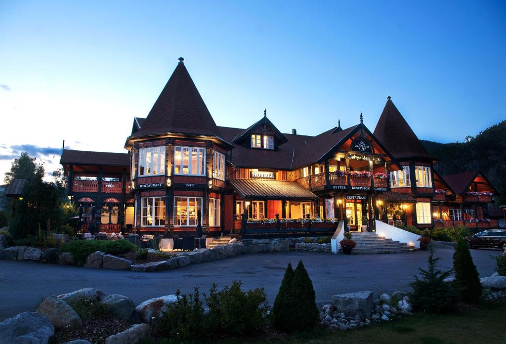 Cette grande maison en bois possède de nombreuses fenêtres. dans l'établissement Sølvgarden Hotel, à Rysstad