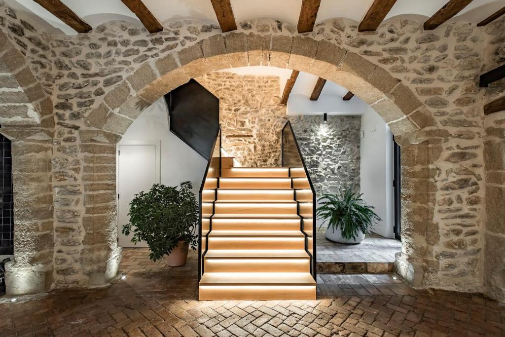 una escalera en un edificio con una pared de piedra en ABBI SUITES Casa Rural, Suites & Spa en Bocairent