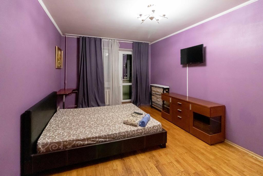 キーウにあるKvartirkoff na Timoshenko 3vの紫の壁のベッドルーム(ベッド1台、テレビ付)