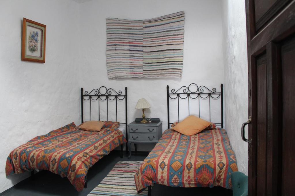 dwa łóżka siedzące obok siebie w sypialni w obiekcie Casa Estrella de las nieves La Alpujarra w mieście Bérchules
