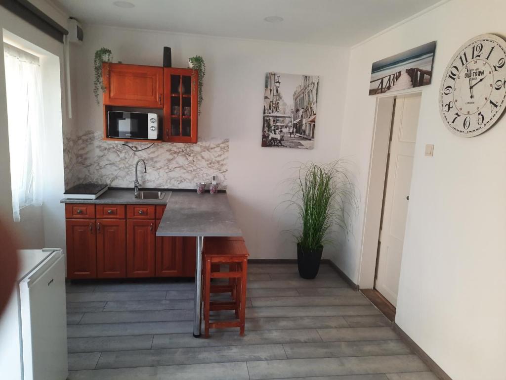 a kitchen with a counter and a clock on the wall at Maja Vendégház in Dunaalmás