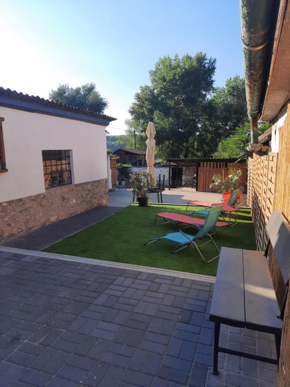 a patio with chairs and a table in a yard at Maja Vendégház in Dunaalmás