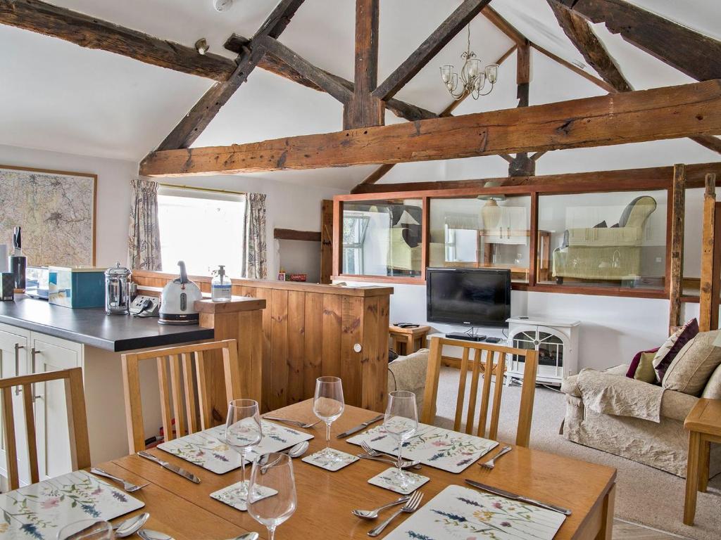 a kitchen and living room with a table with wine glasses at Lavender Cottage - Uk4061 in Buxton