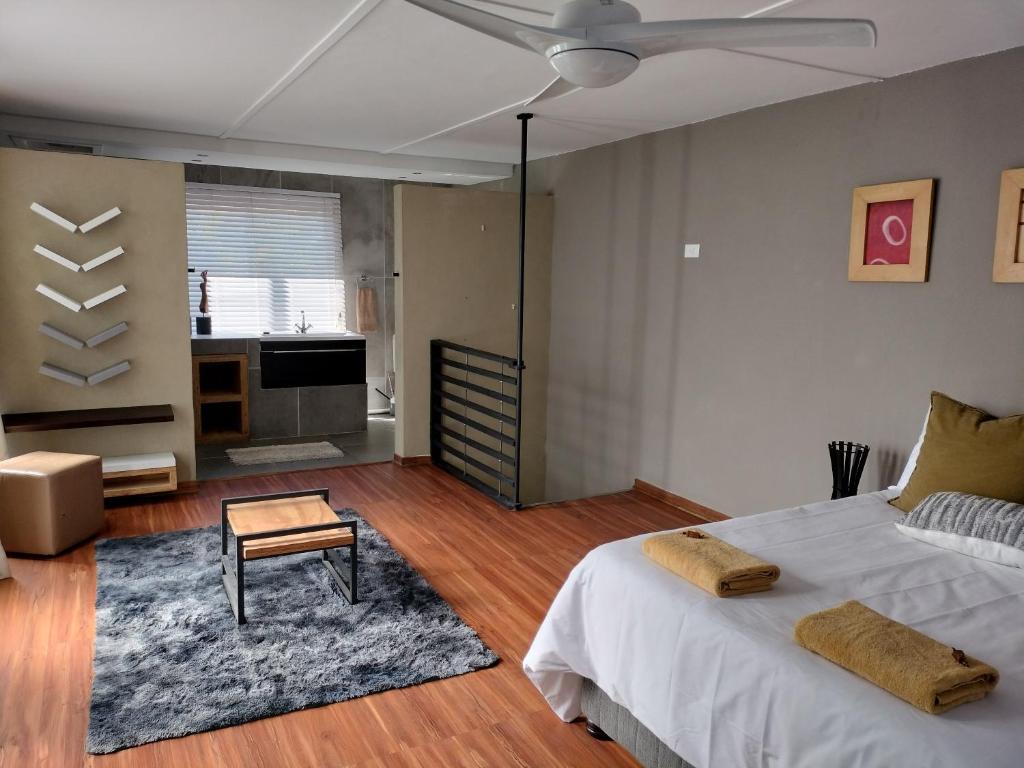 a bedroom with a bed and a living room at Cottages20 in Coffee Bay