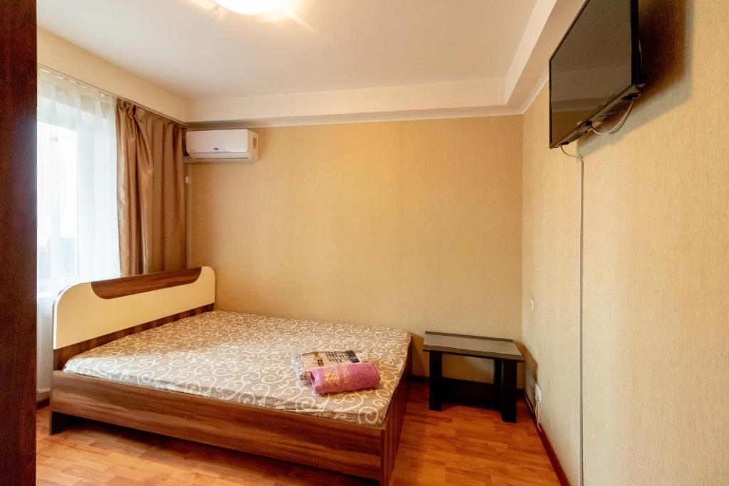 a small bedroom with a bed and a television at Kvartirkoff na Geroev Dnepra 3 in Kyiv