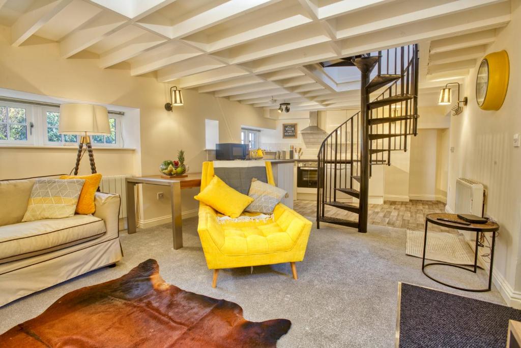 een woonkamer met een gele bank en een trap bij Pass the Keys Homey flat in Sleaford Centre in Sleaford