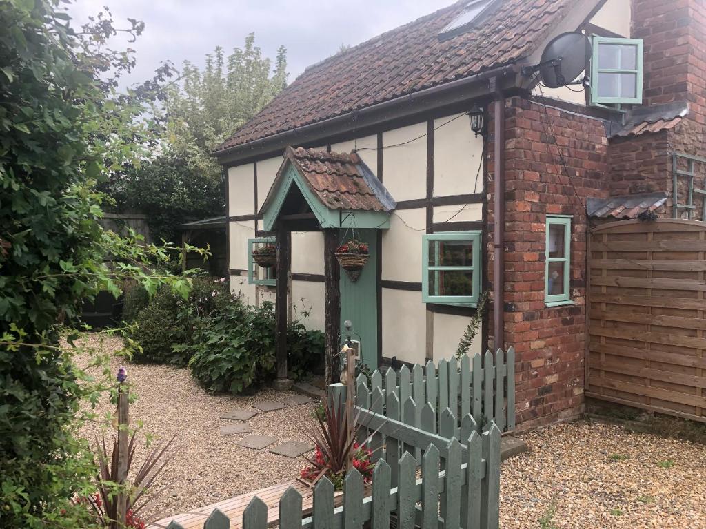 a small house with a fence in front of it at Soldiers Cottage, with HOT TUB, dog friendly, great views in Hereford