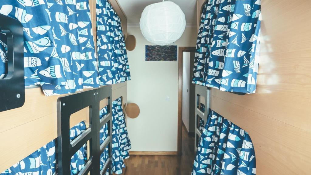 a room with two bunk beds with blue and white sheets at Oportocean Hostel in Matosinhos