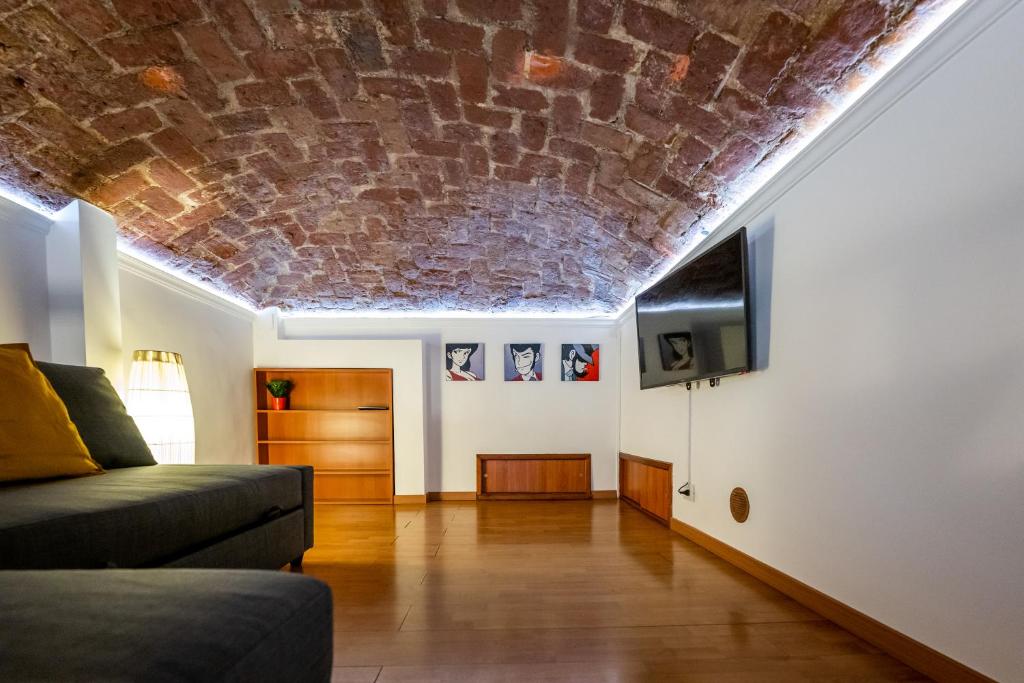 a living room with a brick ceiling and a couch at CasaCasalis - Immersi nella Torino Liberty in Turin
