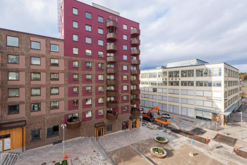 widok na czerwony budynek i dwa budynki w obiekcie Luxury Business Studio Apartment - Garden View w mieście Sundbyberg