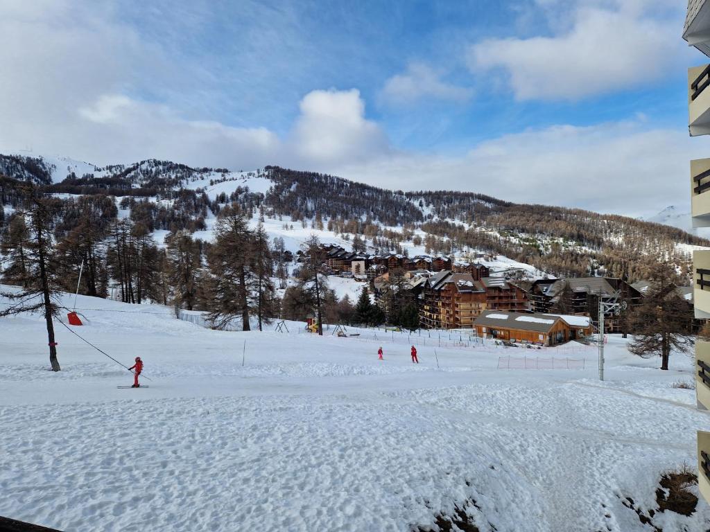 eine Gruppe von Personen, die auf einer schneebedeckten Piste Ski fahren in der Unterkunft Boost Your Immo Risoul Le Diamant 823 in Risoul