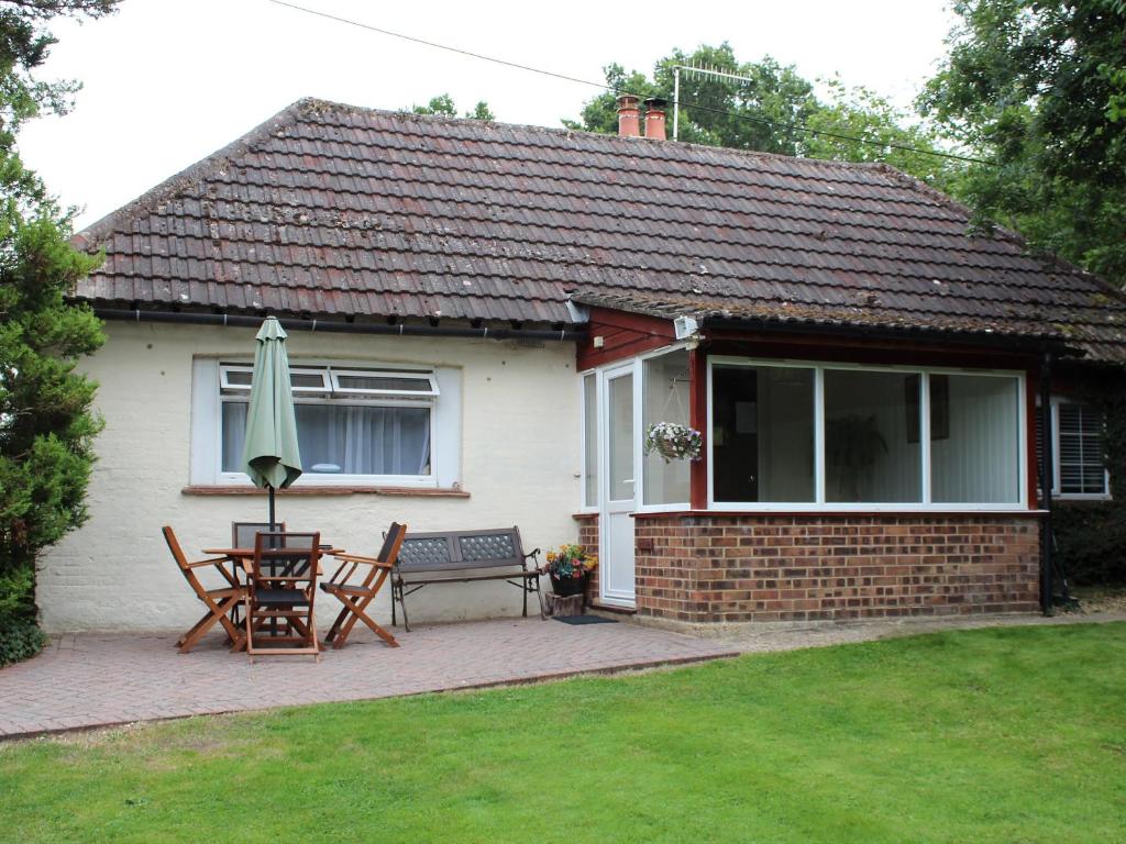 a house with a patio with a table and an umbrella at Brookside in Ellingham
