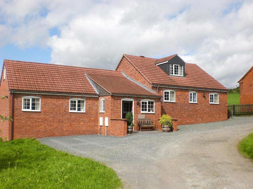 a large red brick house with a driveway at Tom Putt in Ledbury