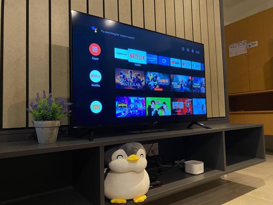 einen TV-Bildschirm mit einem Spielzeugpinguin davor in der Unterkunft 2R1B 5Pax Union Executive Suites Bandar Sunway in Petaling Jaya