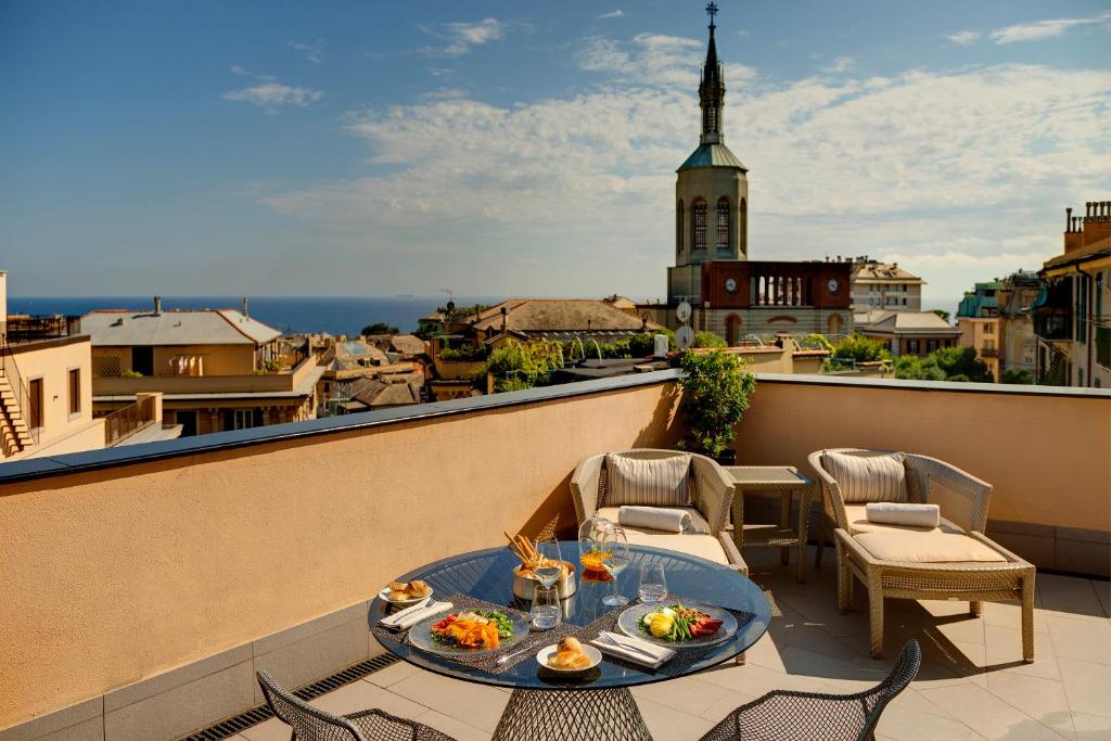 - une table avec de la nourriture sur le balcon dans l'établissement Meliá Genova, à Gênes