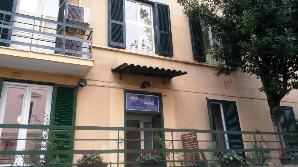 a building with green shutters and a sign on it at Roma Art Rooms in Rome