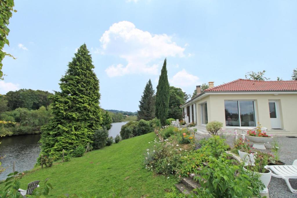 a house with a view of a river at Dominant l'etang in Compreignac