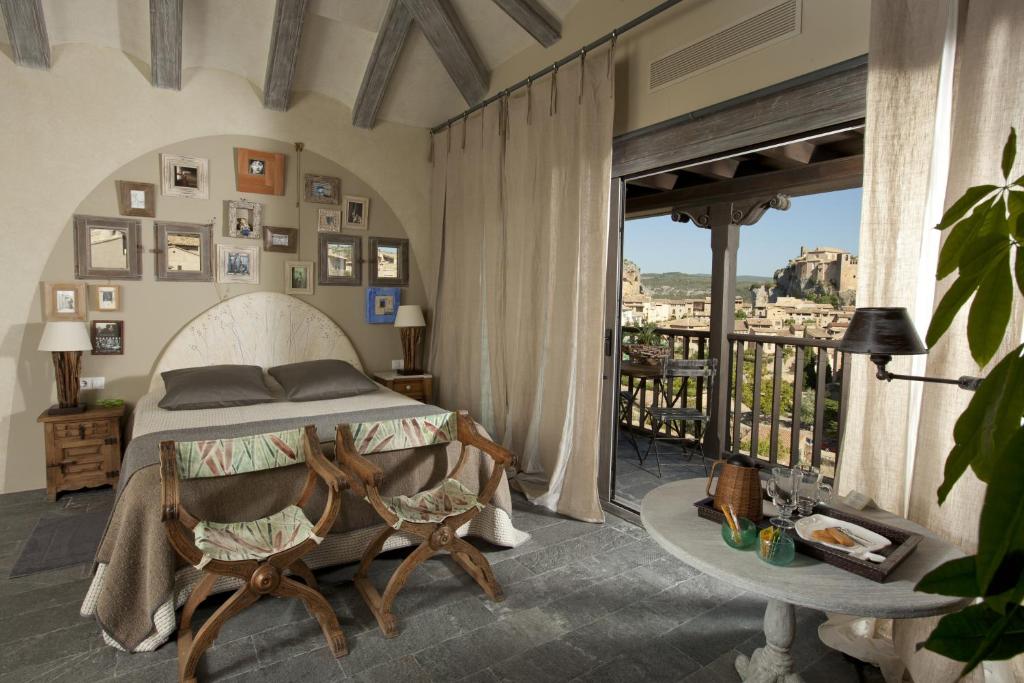 a bedroom with a bed and a balcony at Alodia in Alquézar