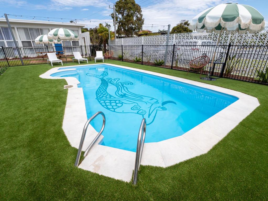 a swimming pool with a fish stencil on it at Mermaid Apartments in Merimbula