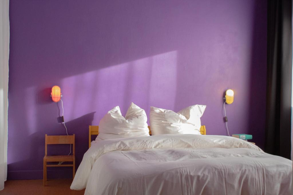 デュースブルクにあるnew design apartmentの紫色のベッドルーム(白いシーツと枕付きのベッド1台付)