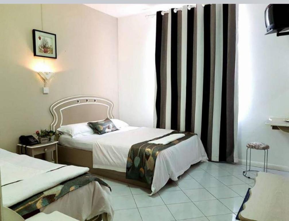Habitación de hotel con 2 camas y ventana en Euro Vacances Guest House, en Roches Brunes