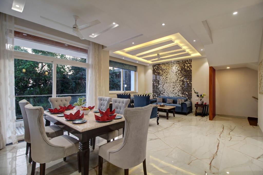 Antalya Villa - 5BHK with Private Pool, Baga في باغا: غرفة طعام وغرفة معيشة مع طاولة وكراسي