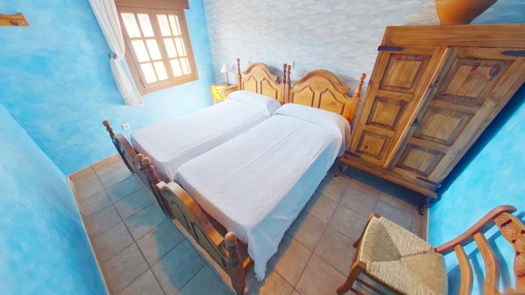 una camera con un letto in una camera blu di Casa RuralRut en El Tiemblo, zona de baño natural muy cercana y a solo 50 min de Madrid a El Tiemblo