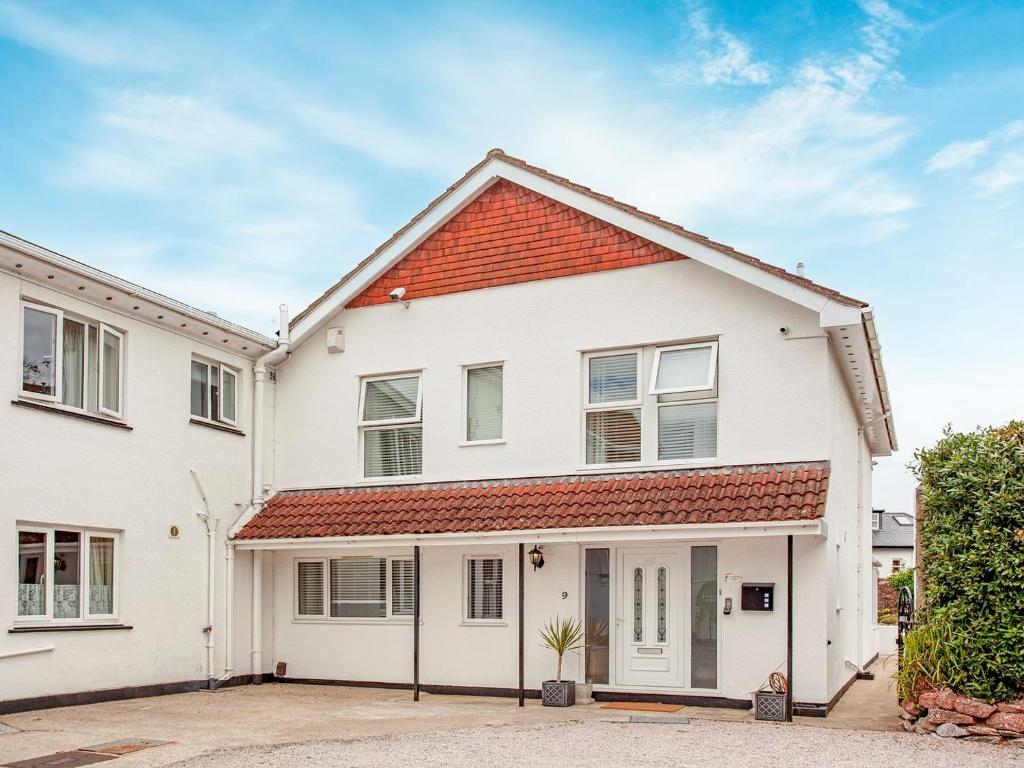 uma casa branca com um telhado vermelho em Flower Pots House - Uk39782 em Paignton